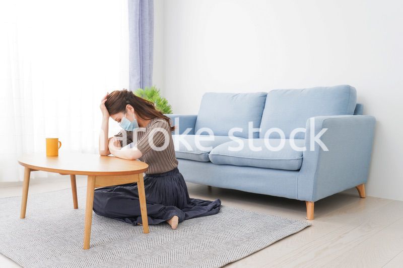 体調不良に苦しむマスクをつけた女性
