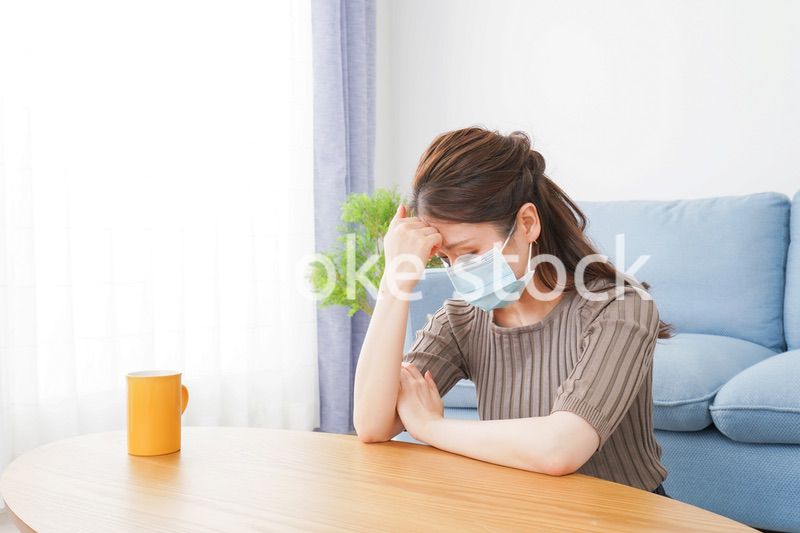体調不良に苦しむマスクをつけた女性