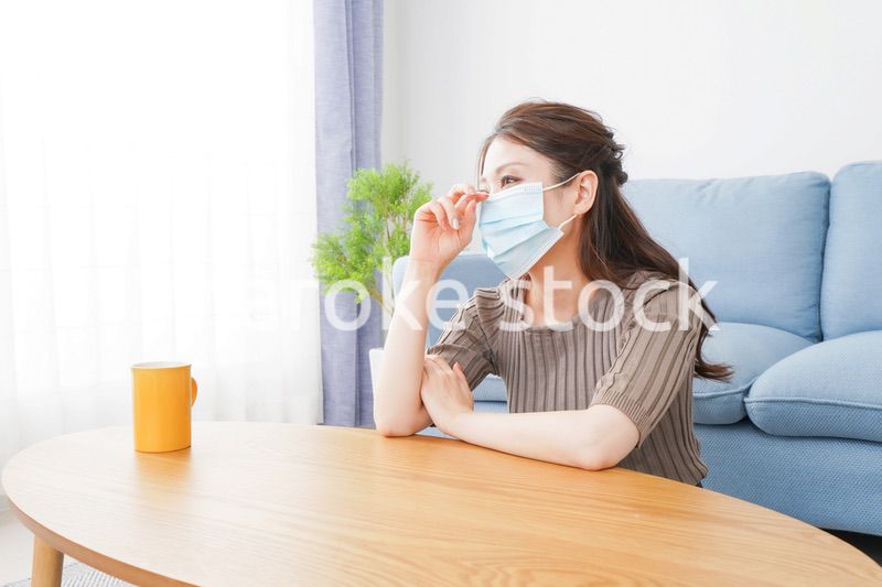 体調不良に苦しむマスクをつけた女性