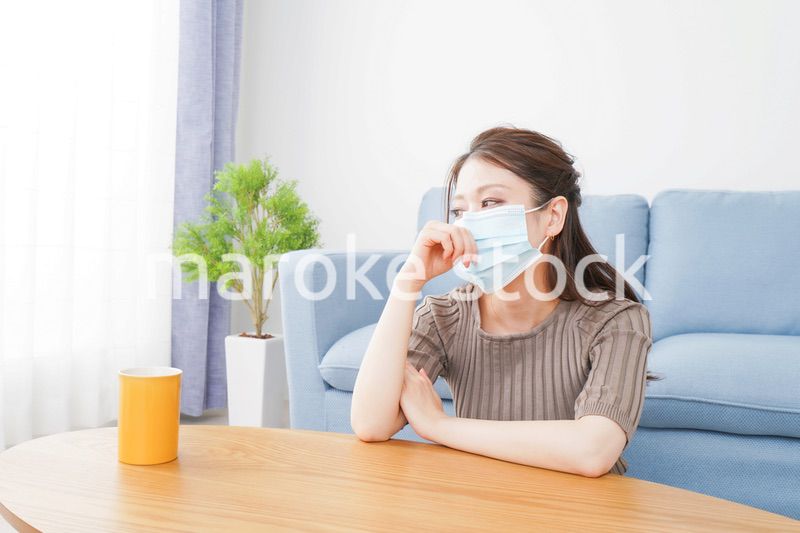 体調不良に苦しむマスクをつけた女性