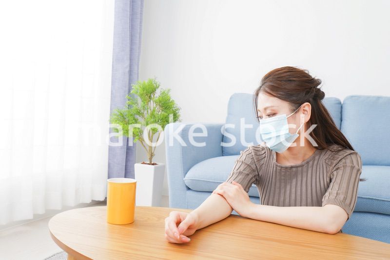 体調不良に苦しむマスクをつけた女性