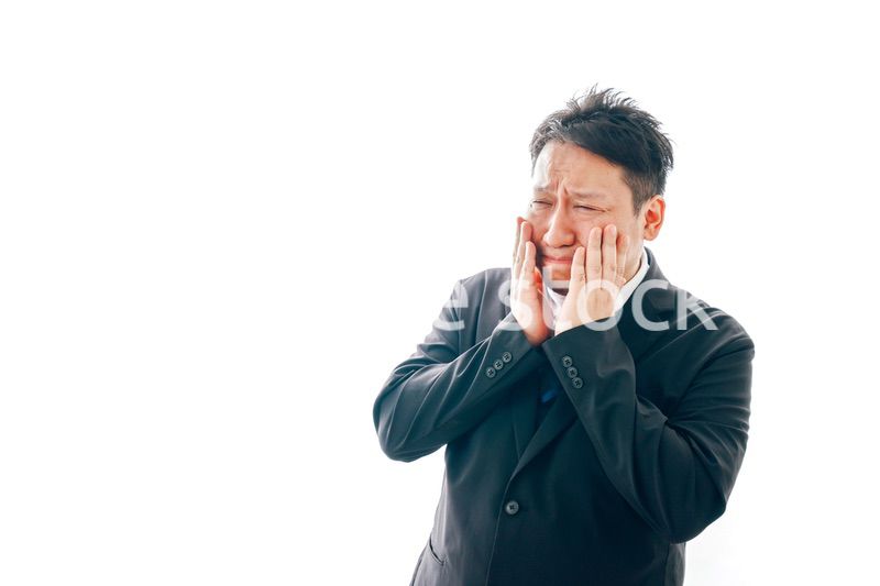 ひどく悲しむスーツを着た中年男性