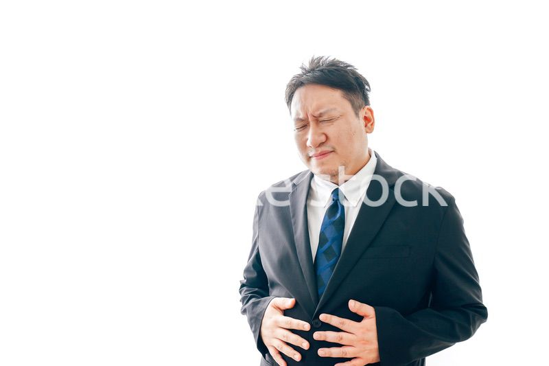 腹痛に苦しむスーツを着た中年男性