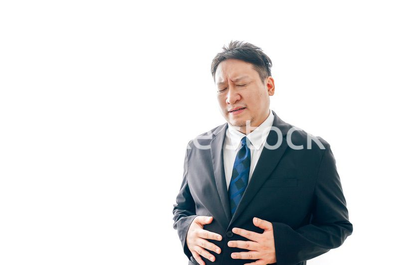 腹痛に苦しむスーツを着た中年男性