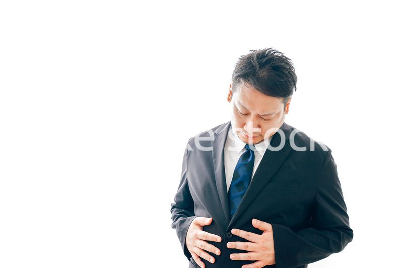 腹痛に苦しむスーツを着た中年男性