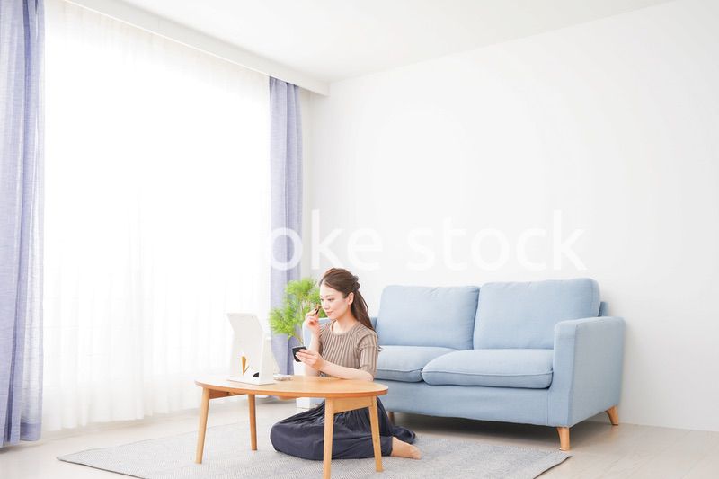 一人暮らしの部屋で化粧をする女性