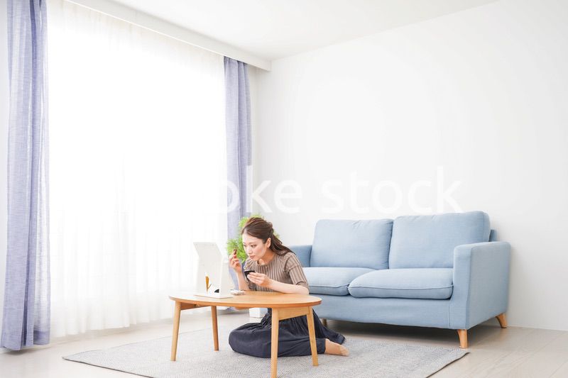 一人暮らしの部屋で化粧をする女性