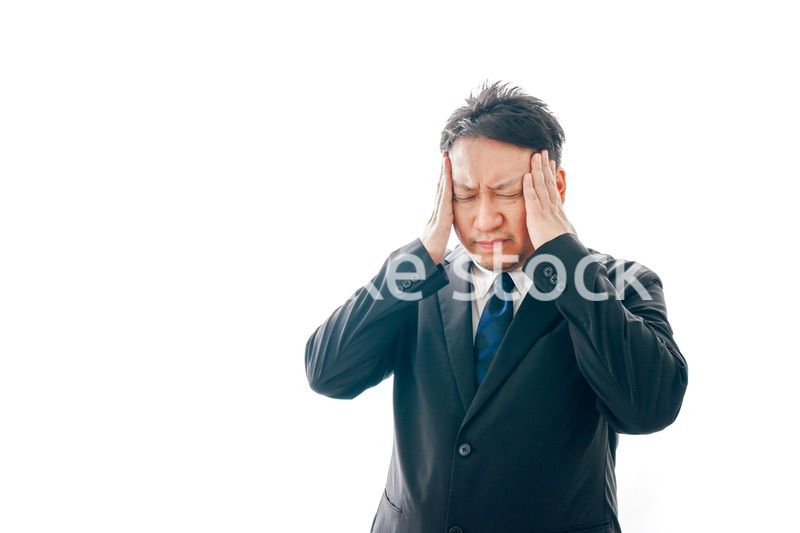 頭痛に苦しむスーツを着た中年男性