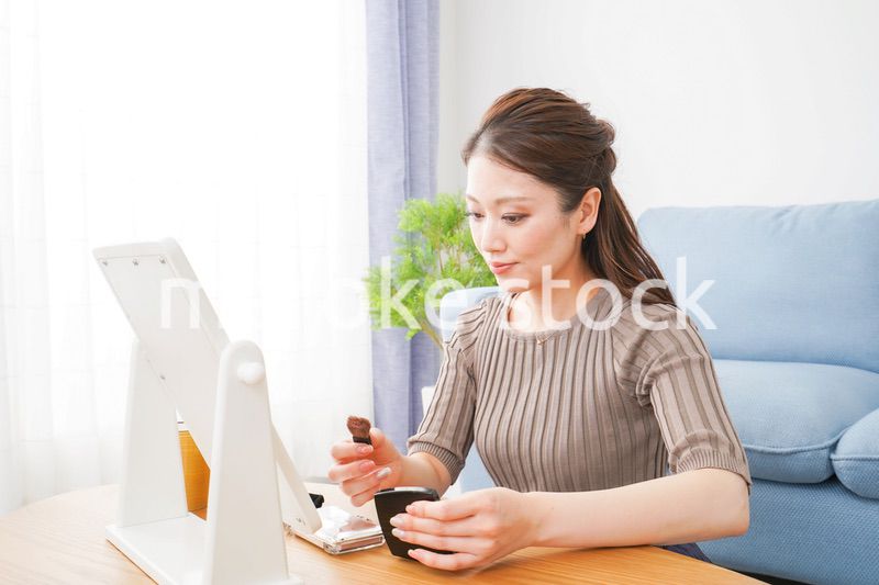 一人暮らしの部屋で化粧をする女性