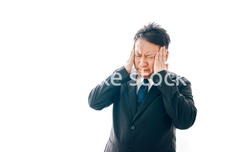 頭痛に苦しむスーツを着た中年男性