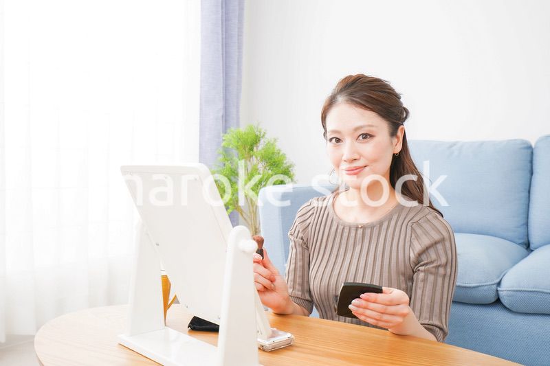 一人暮らしの部屋で化粧をする女性