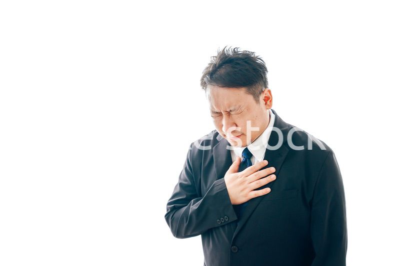 胸の痛みに苦しむスーツを着た中年男性