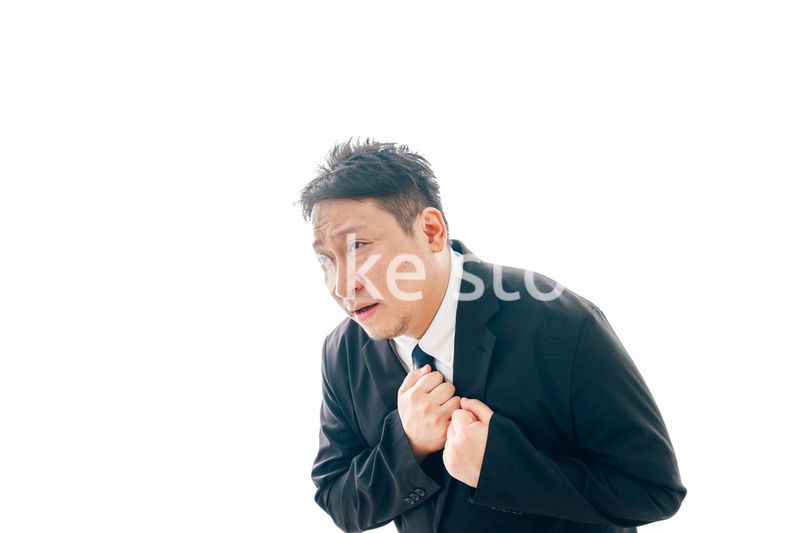 胸の痛みに苦しむスーツを着た中年男性