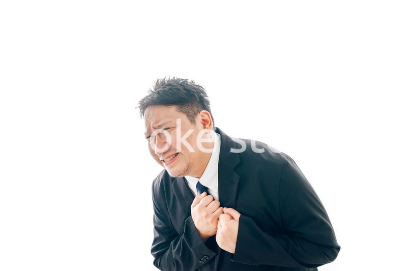 胸の痛みに苦しむスーツを着た中年男性