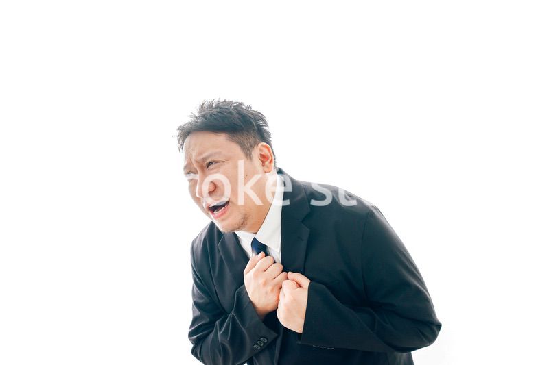 胸の痛みに苦しむスーツを着た中年男性
