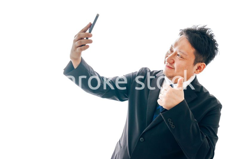 自撮りをするスーツを着た中年男性