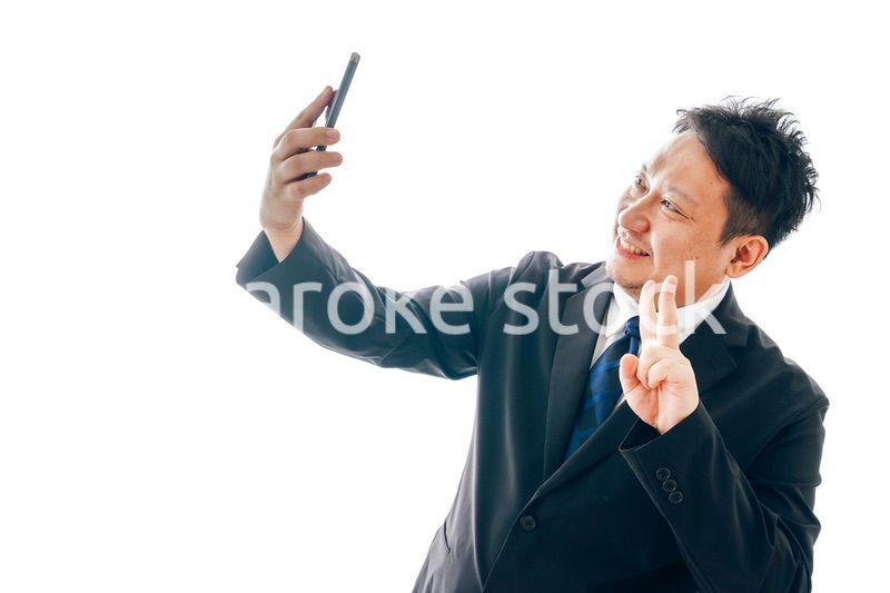 自撮りをするスーツを着た中年男性