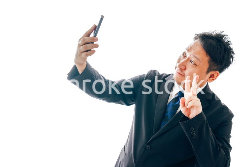 自撮りをするスーツを着た中年男性