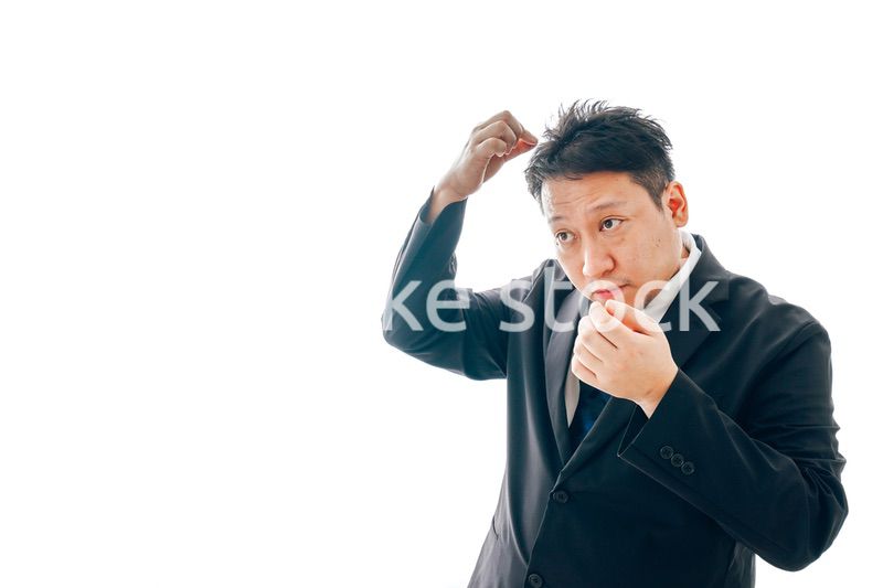 抜け毛に悩むスーツを着た中年男性