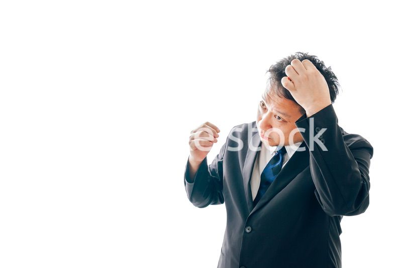 抜け毛に悩むスーツを着た中年男性