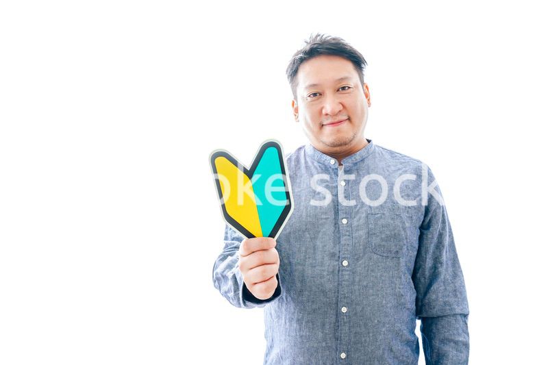 初心者マークを持つ中年男性