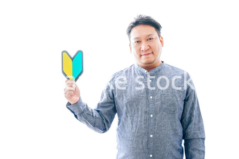 初心者マークを持つ中年男性