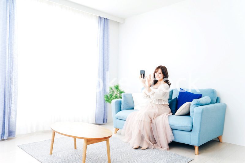 スマートフォンでライブ配信をする若い女性