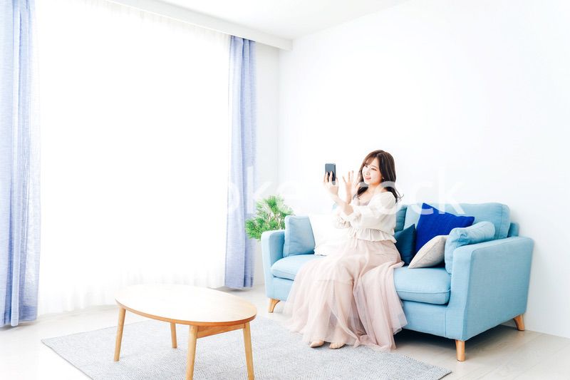 スマートフォンでライブ配信をする若い女性