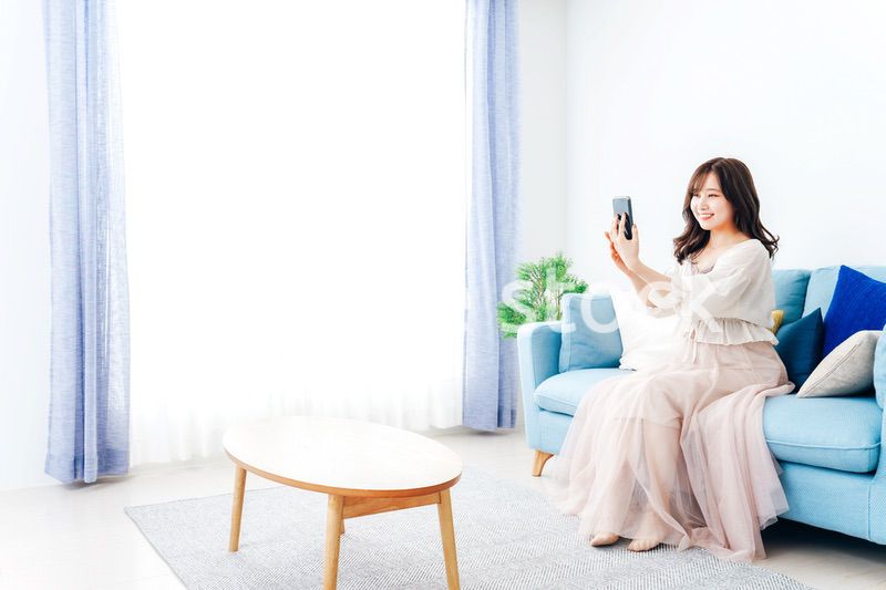 スマートフォンでライブ配信をする若い女性