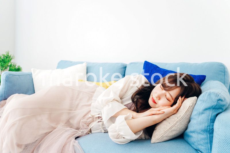 ソファーで仮眠を取る若い女性