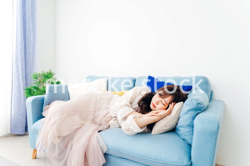 ソファーで仮眠を取る若い女性