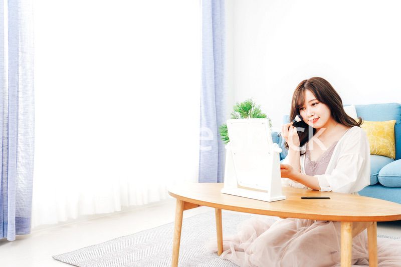 自宅でメイクをする若い女性