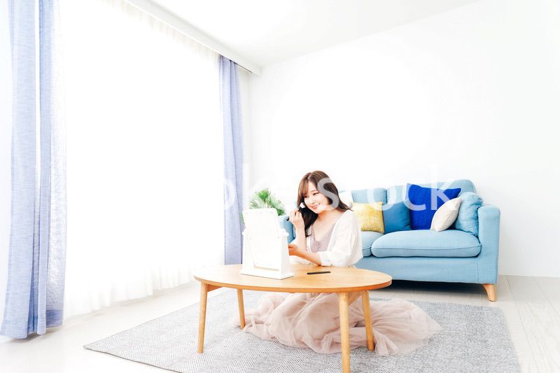 自宅でメイクをする若い女性