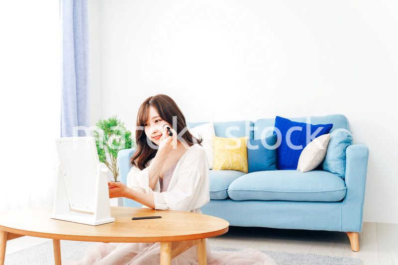 自宅でメイクをする若い女性