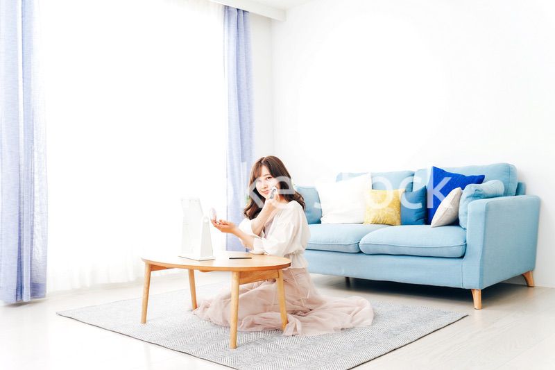 自宅でメイクをする若い女性