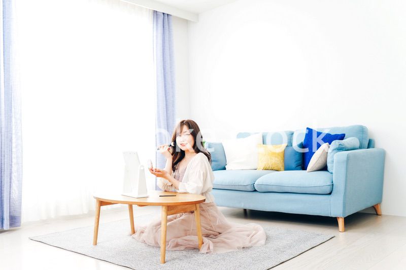 自宅でメイクをする若い女性