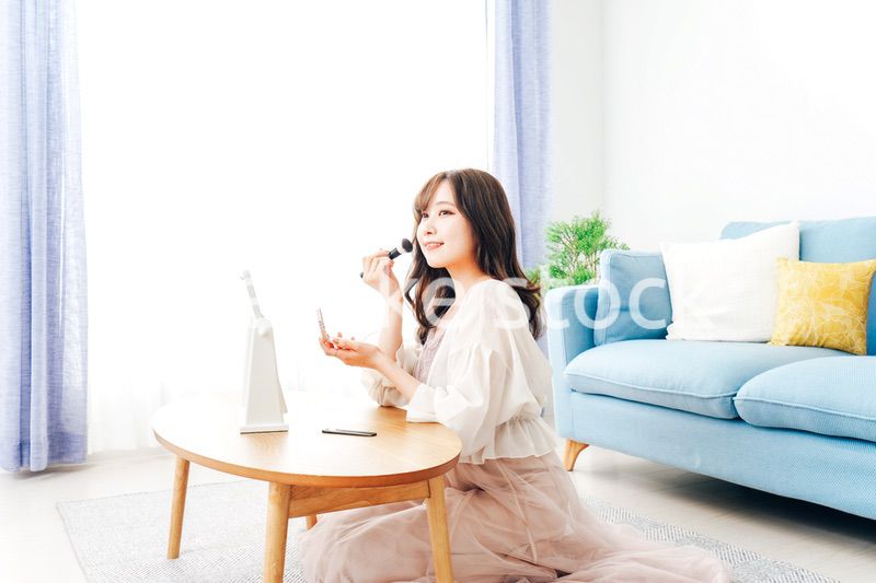自宅でメイクをする若い女性
