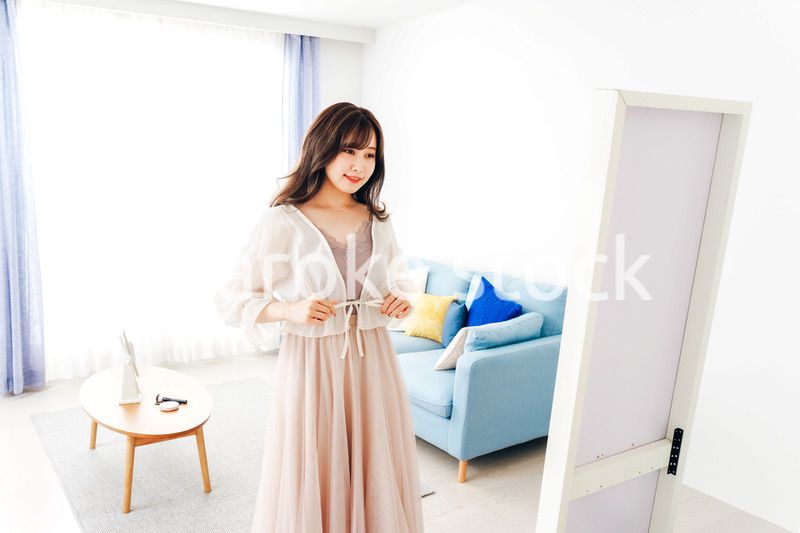 自宅で服を着替える若い女性