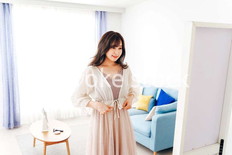 自宅で服を着替える若い女性