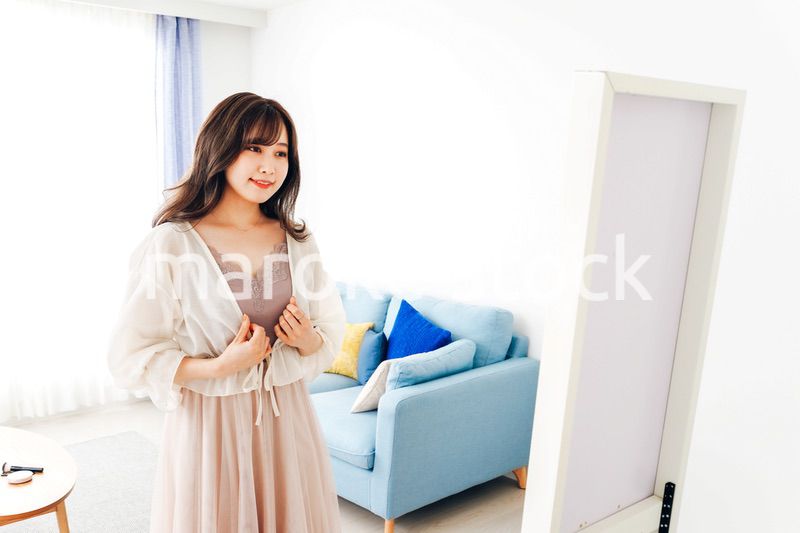 自宅で服を着替える若い女性