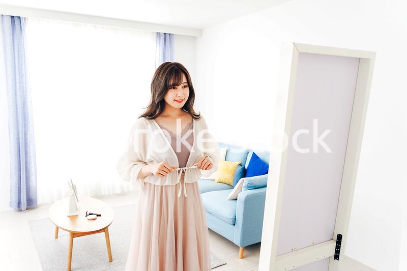 自宅で服を着替える若い女性