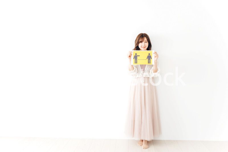 ソーシャルディスタンスの案内を持つ若い女性