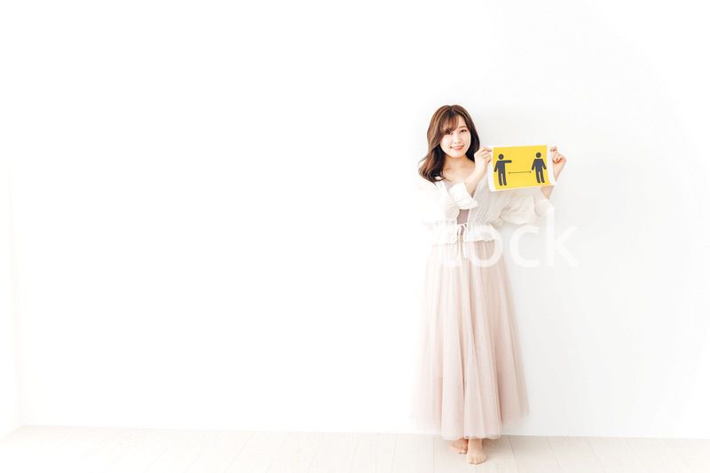 ソーシャルディスタンスの案内を持つ若い女性