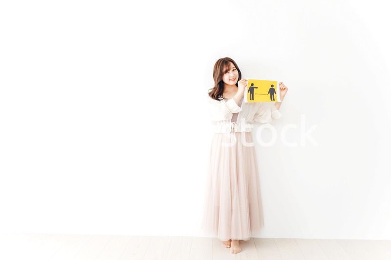 ソーシャルディスタンスの案内を持つ若い女性