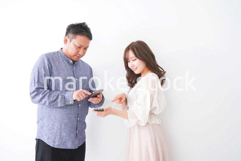 スマホで連絡先を交換する若い男女