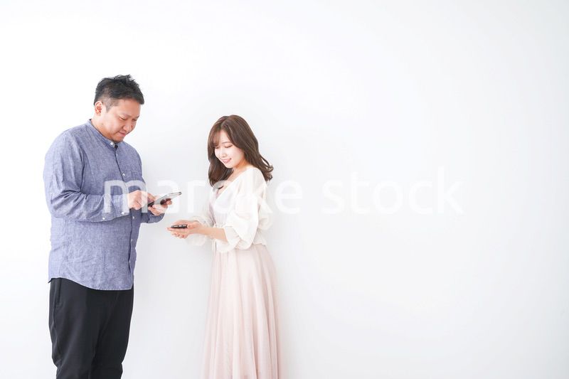 スマホで連絡先を交換する若い男女