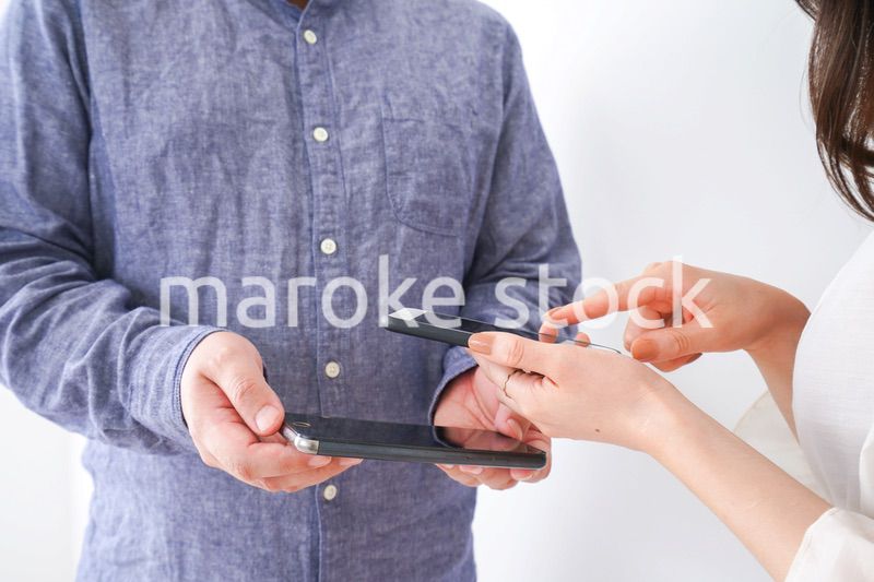 スマホで連絡先を交換する若い男女