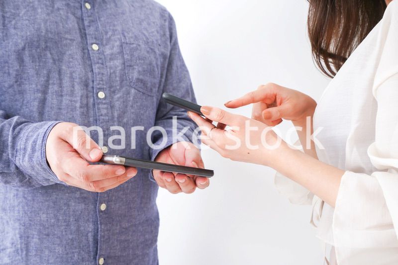 スマホで連絡先を交換する若い男女