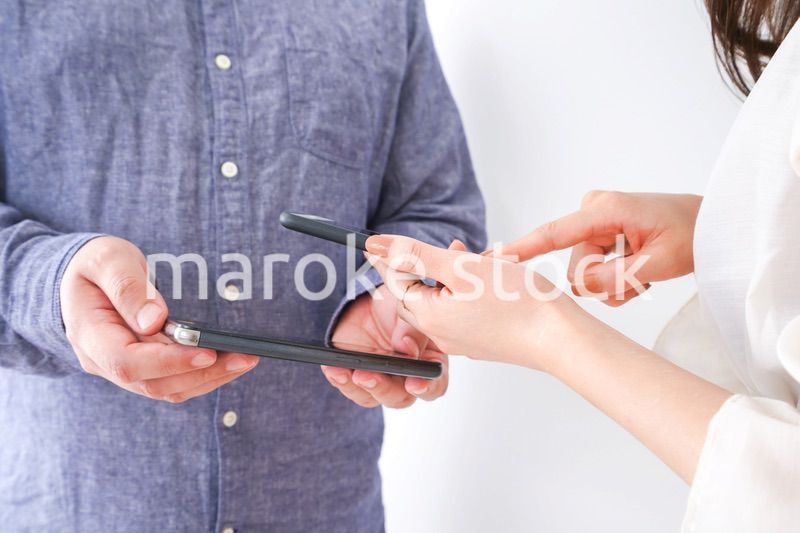 スマホで連絡先を交換する若い男女