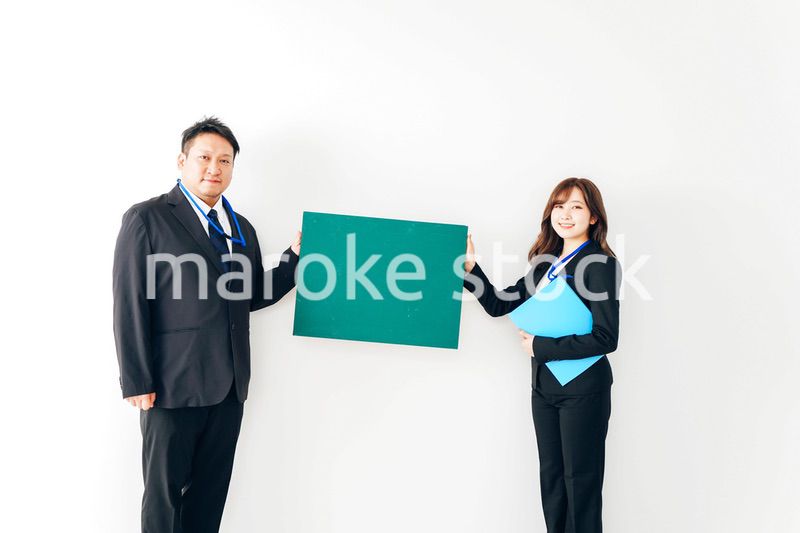 黒板を持つスーツを着た2人のビジネスパーソン